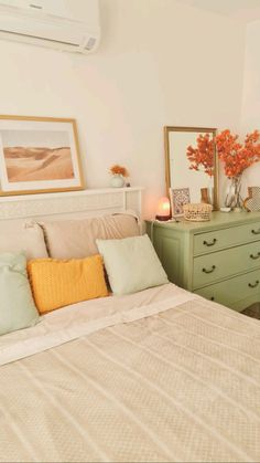 a bedroom with a bed, dresser and pictures on the wall next to each other