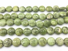 green beads are lined up on a white surface