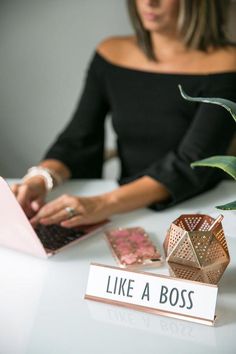 a woman sitting at a table working on her laptop