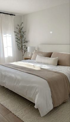 a bedroom with a large bed and white walls