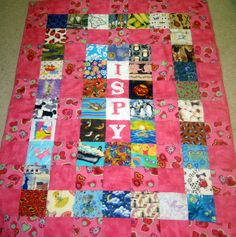 a pink quilt with pictures on it that says i spyy in white letters and hearts