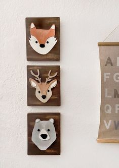 three wooden animal heads mounted to the side of a wall next to a sign that says abc for animals