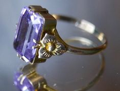 Antique Victorian delicate gold ring with dazzling emerald cut amethyst gemstone in elegant basket setting with belle epoch floral motifs on shank. Photographs cannot do justice to this beautiful piece.  Stamped as shown in photographs. Excellent vintage condition. Ring size: Adjustable, US 7 / 17.5 mm Gemstone length: 1.4 cm ☞ Please view my shipping and sales policies and ✎ Contact me with questions prior to purchase...all sales are final. http://www.etsy.com/shop/Andeebird/policy Luxury Emerald Cut Amethyst Wedding Ring, Elegant Emerald Cut Purple Jewelry, Elegant Purple Emerald Cut Jewelry, Classic Amethyst Ring With Rectangular Stone For Formal Occasions, Rectangular Amethyst Ring For Formal Events, Rectangular Amethyst Ring For Formal Occasions, Elegant Rectangular Amethyst Ring For Formal Occasions, Elegant Purple Amethyst Bezel Setting Ring, Elegant Purple Amethyst Ring With Bezel Setting