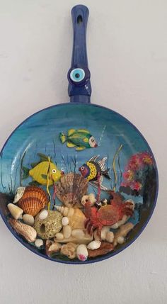 a blue plate with fish on it hanging from the wall in front of a white wall