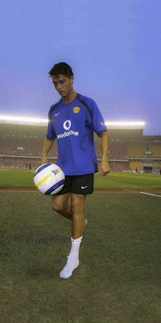 a man holding a soccer ball on top of a field