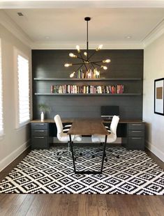 a room with a table, chairs and bookshelves on the wall above it