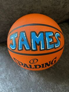 an orange and blue basketball with the word james on it