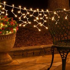 an outdoor bench with lights on it and a potted plant in the foreground