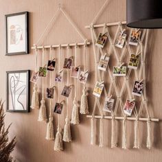 a wall with pictures hanging on it next to a wooden chair and vase filled with flowers