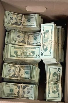 a cardboard box filled with twenty dollar bills