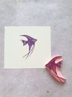 a piece of paper with a purple fish on it