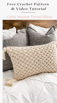 the crochet pillow is on top of a bed with white sheets and pillows