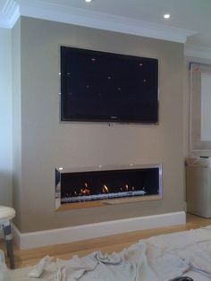 a tv mounted on the wall above a fireplace