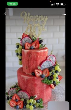 a three tiered cake with fruit on top