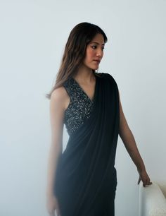 Elevate your evening look effortlessly with this pre-stitched sari. It features a knot-drape skirt in shimmery black georgette with an attached drape and a sleeveless beaded blouse boasting a plunging v-neckline. This ensemble is lightweight and effortlessly chic, making a striking statement perfect for cocktail parties or evening festivities under the stars. Drape Sari, Personal Shopping Service, Beaded Blouse, Cocktail Parties, Silhouette Free, Midnight Black, Delicate Details, Under The Stars, Sheer Fabrics