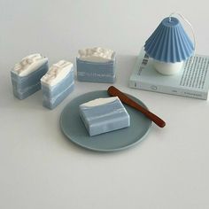 some soaps are sitting on a plate next to a book and an object that looks like a seashell