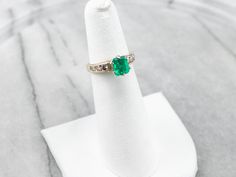 This emerald and diamond ring is classic, yet dazzling! The emerald is hypnotic and dreamy, with an iconic green hue that can't help but draw your eye. Bright and sparkling diamonds cascade down the shoulders of the ring, creating a gorgeous play of light. Metal: Platinum (Head), 14K Yellow Gold Gem: Emerald .94 Carats Gem Measurements: 4.6 x 6.4 mm, Emerald Cut Accents: 6 Diamonds totaling .42 Carats, SI in Clarity, H in Color Ring Size: 4.25 Marks: "88 14K" Stamped on the inside band Green Emerald Ring With Diamond Accents, Green Diamond Ring With Vvs Clarity For May Birthstone, Emerald Cut Green Diamond Ring With Diamond Accents, Emerald Cut Green Diamond Ring With Accents, Emerald Green Diamond Ring With Brilliant Cut, Green Emerald Diamond Ring With Accents, Green Diamond Ring With Vvs Clarity Round Cut, Green Diamond Ring With Vvs Clarity, Fine Green Diamond Ring With Vvs Clarity