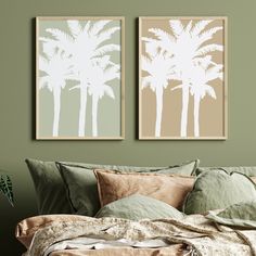 two palm trees are hanging on the wall above a bed with green sheets and pillows