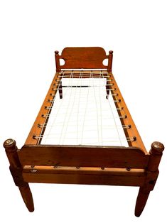 a wooden bed frame with white sheets and wood posts on the headboard is shown in front of a white background