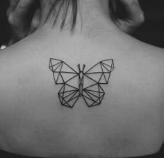 the back of a woman's neck with a geometric butterfly tattoo on her left shoulder