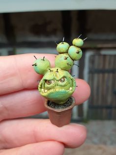 a tiny green plant with eyes and antennae