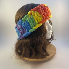 a wig with a multicolored knitted headband on it's side