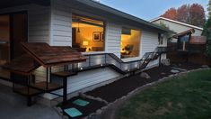 a house that has some lights on the front porch and stairs leading up to it