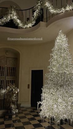 a white christmas tree sitting in the middle of a room