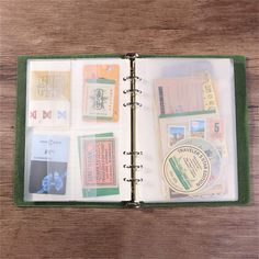 an open book on a wooden table with many different items in the cover and inside