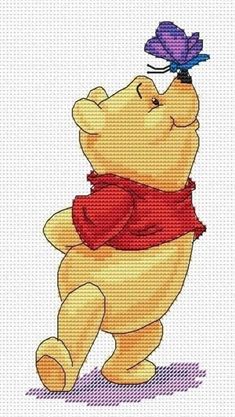 a cross stitch winnie the pooh bear with a purple butterfly on its head and red scarf