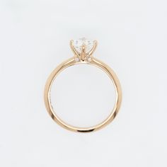 a yellow gold ring with a single diamond on the center and side stones at the top