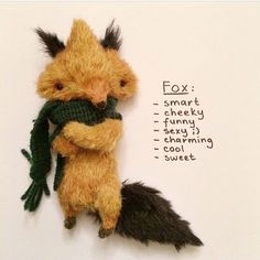 a small stuffed animal with a green scarf on it's back and the words fox written below