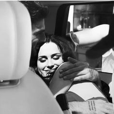 black and white photograph of a woman in the back seat of a car with her face painted