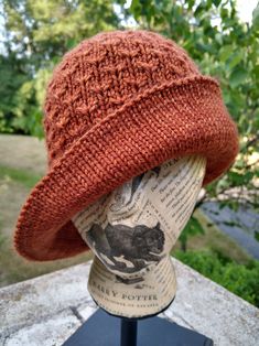 an orange knitted hat on top of a mannequin head