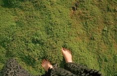 a person standing in the grass with their feet up and hands on each other's hips