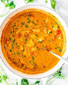 a white bowl filled with curry and chicken