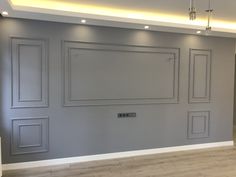 an empty room with gray painted walls and white trimmings on the wall, along with recessed lighting