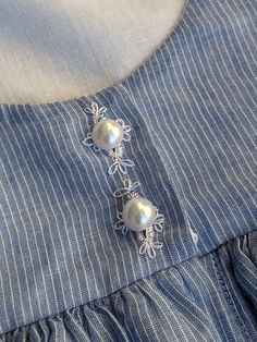 a close up of a shirt with pearls on it