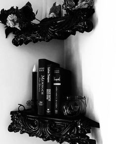 black and white photograph of two books on shelf with candle, wine glass and candlestick