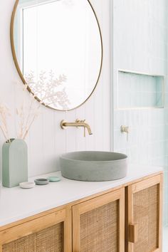 a bathroom with a round mirror above the sink