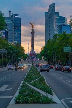 a city street filled with lots of traffic and tall buildings in the backgroud