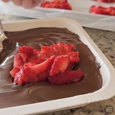 chocolate and strawberries in a white dish on a table