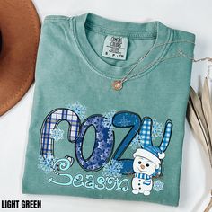 Pre-shrunk T-shirt As Winter Gift, Short Sleeve Graphic T-shirt For Winter, Winter Short Sleeve Tops With Letter Print, Short Sleeve Tops With Letter Print For Winter, Cozy Cotton Christmas Tops, Cozy Blue Top With Letter Print, Cotton T-shirt For Winter Gift, Casual Cotton T-shirt For Holiday, Winter Gift Cotton T-shirt