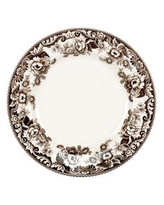 an ornately decorated plate with flowers and leaves on the rim, against a white background