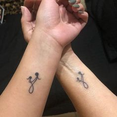 two people are holding hands with tattoos on their arms and one has a stethoscope