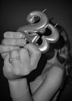 a woman holding up a metal object in her hands