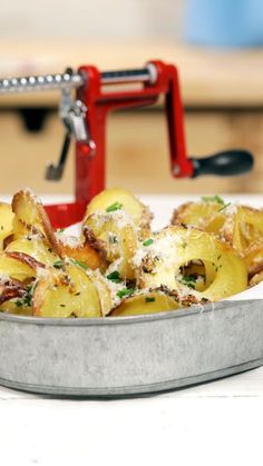 a metal pan filled with cooked potatoes covered in parmesan cheese