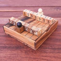 a wooden board game set with numbers and dices on the top, sitting on a wood surface