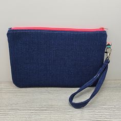 a blue denim pouch with a red zipper