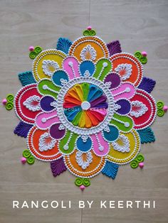 an intricately designed wall hanging made from colorful threads and beads with the words rangoli by keerthi on it